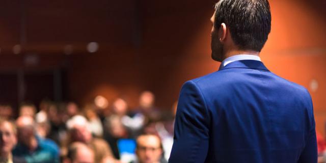 53599727 - speaker giving a talk on corporate business conference. audience at the conference hall. business and entrepreneurship event.