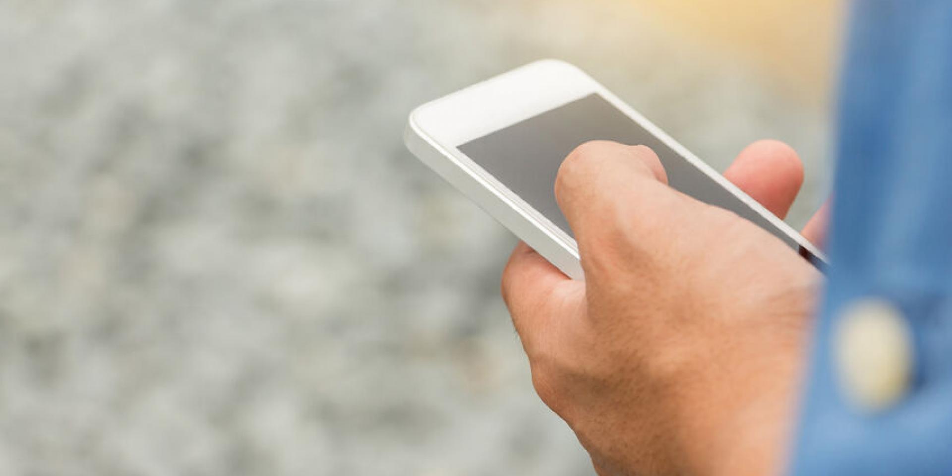 Close up of Engineering Businessman in blue jeans using mobile smartphone blurry background.