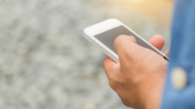 Close up of Engineering Businessman in blue jeans using mobile smartphone blurry background.