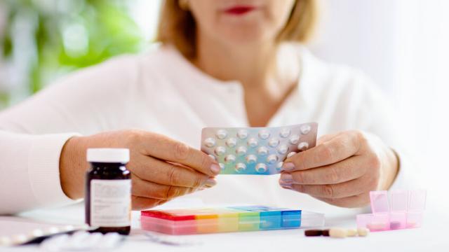 Pill box for senior patient. Medicine container. Elderly woman sorting drug pills for pain relief and disease treatment. Sick retired female with drugs. Daily vitamins for healthy retirement.